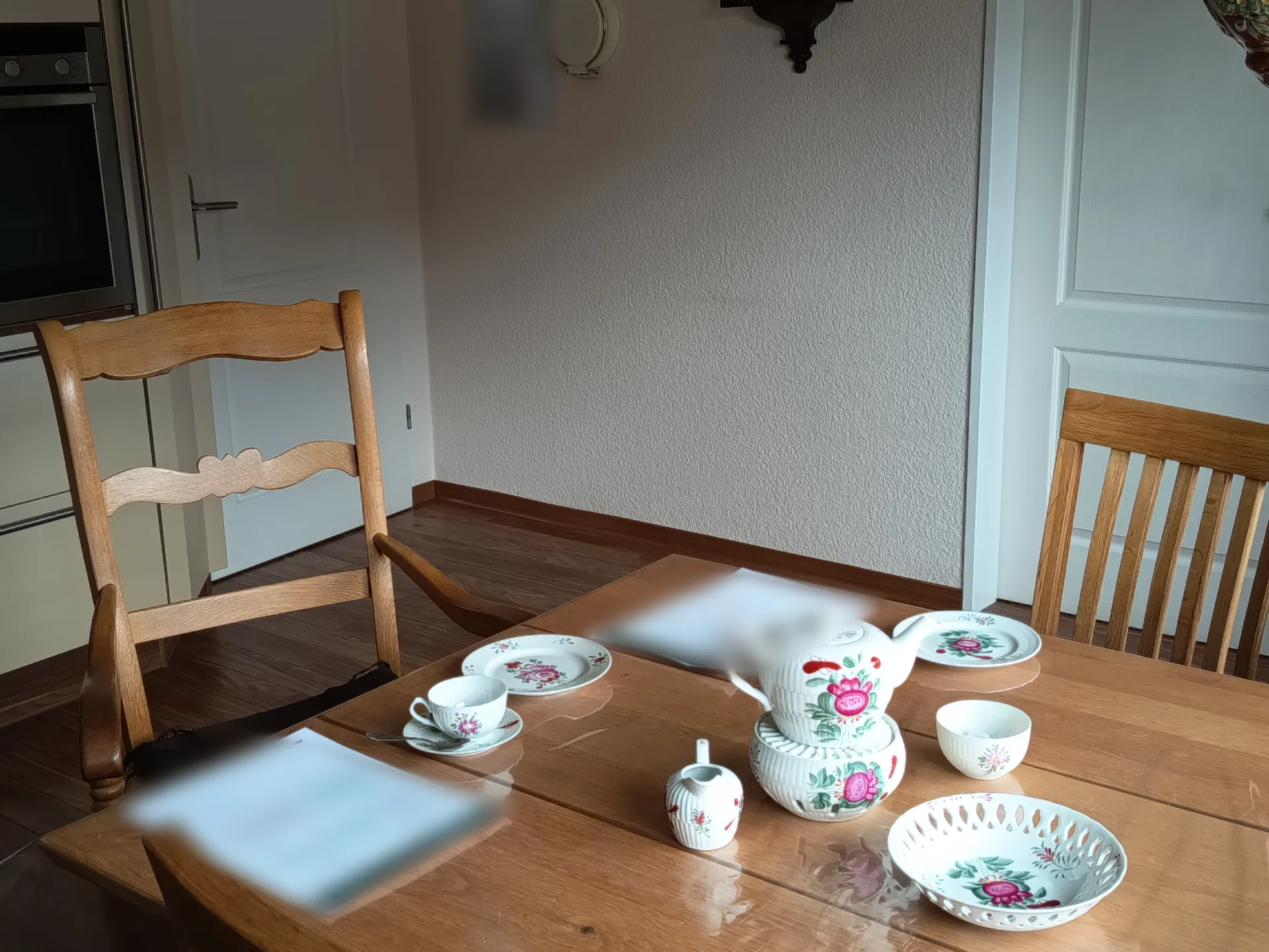 Teekanne auf Stövchen neben Unterlagen, Beratungstermin zum Hausverkauf bei Kunden zu Hause in Ostfriesland
